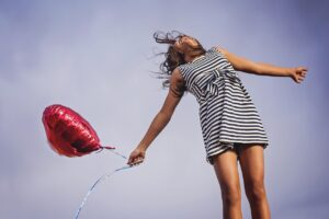 woman floating in air with a balloon